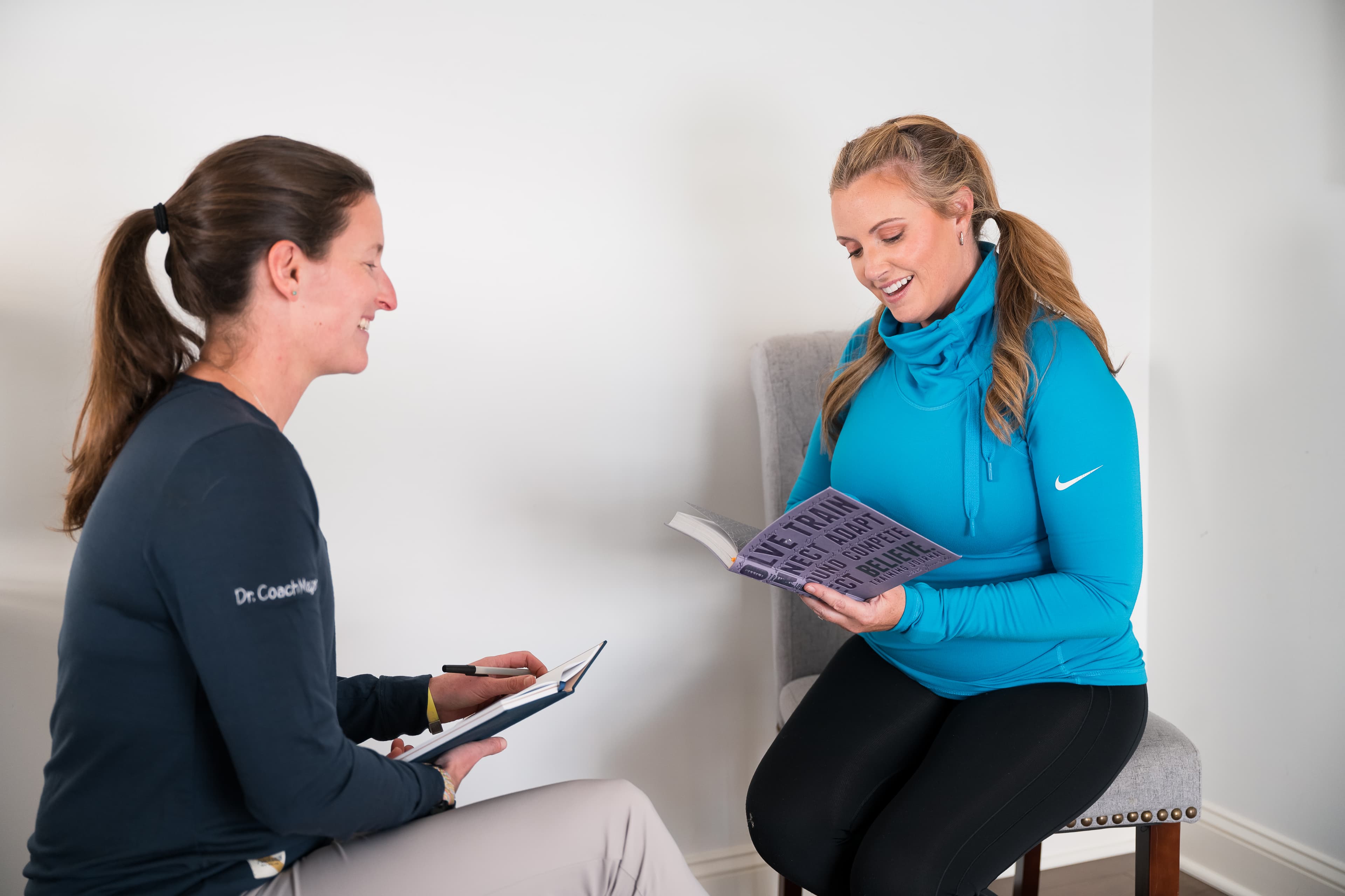 Megan James reviewing a training journal with a client during a coaching consult